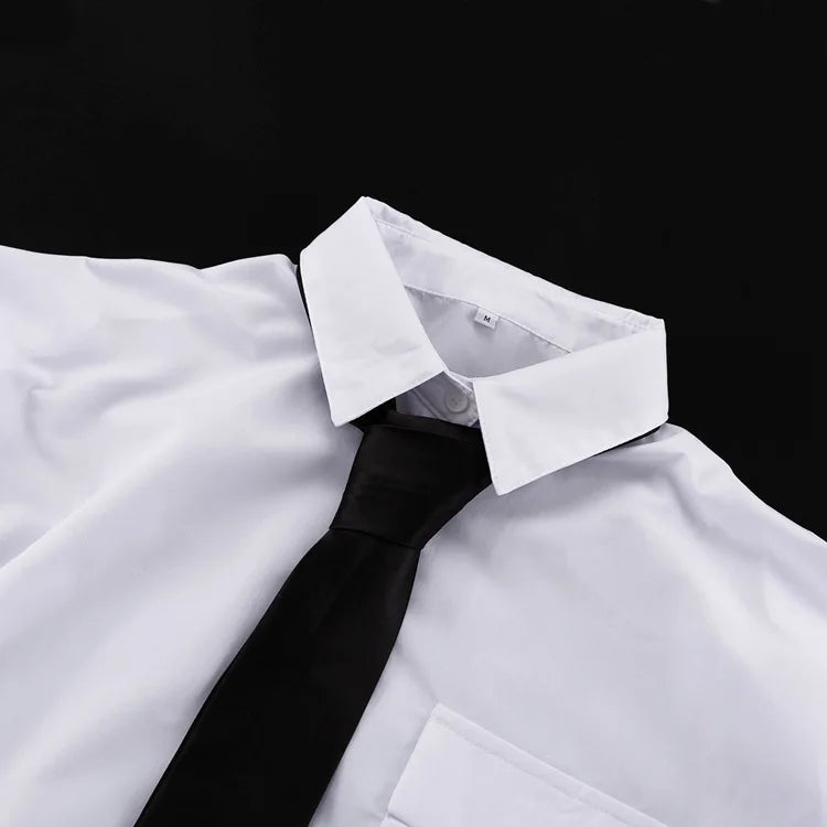 Close-up of a white shirt with a black tie against a black background