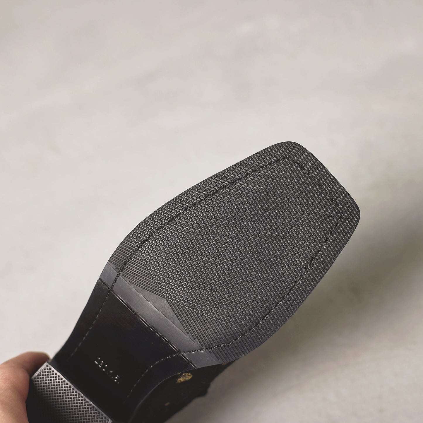 Black and gray shoe with a textured sole on a light background