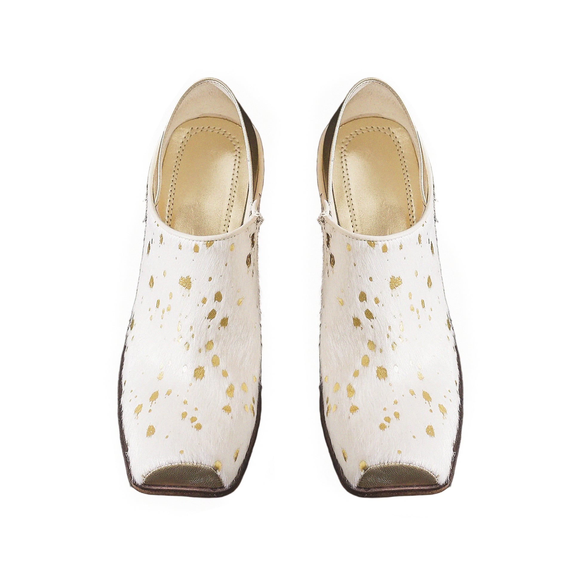Pair of white shoes with gold speckles on a white background