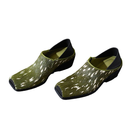 Pair of green clogs with white patterns on a white background